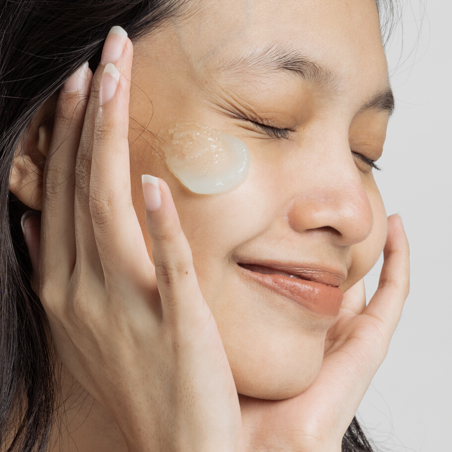 Closeup Portrait of Smiling Woman with Moisturizer
